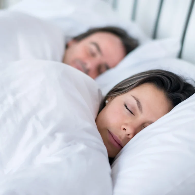 Couple comfortably sleeping in bed